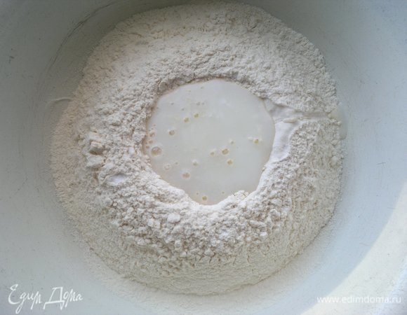Понемногу вливать кефир и перемешивать его с мукой.