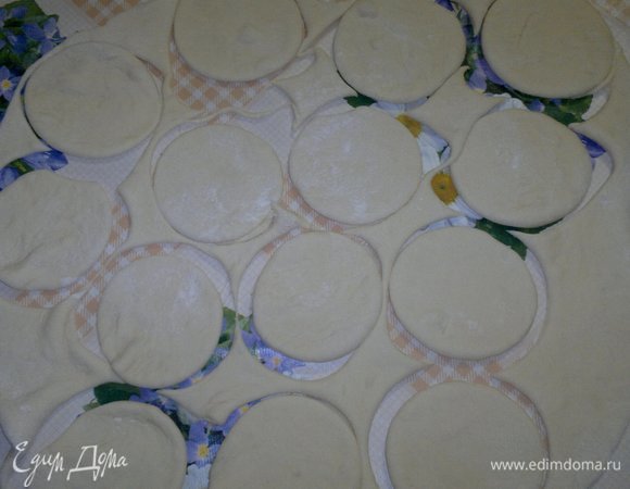 Тесто для вареников раскатать в тонкий пласт на подпыленном мукой столе. Стаканом вырезать кружки.