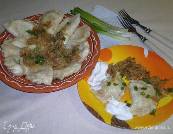 Готовые вареники выложить в тарелку. Сверху положить обжаренный лук и мелко нарезанный зеленый лук. Подавать вареники со сметаной. Приятного аппетита! Со старым Новым годом!