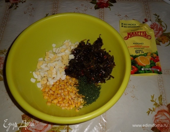 В чашку выкладываем кукурузу, морскую капусту, нарезанное яйцо и зелень.