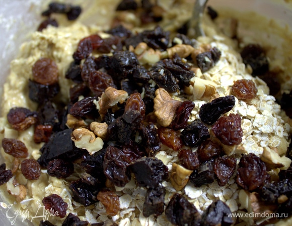 Добавить в тесто изюм, чернослив четвертинками и грецкий орех кусочками.