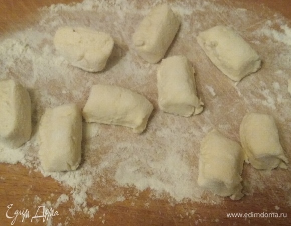 Доску посыпать мукой. Из небольшой порции теста скатать колбаску. Нарезать на сегменты.