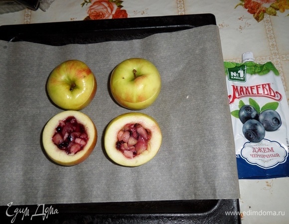Противень застилаем пергаментом. Выкладываем на пергамент яблоки. Внутрь каждого выкладываем приготовленную яблочно-черничную начинку. Накрываем срезанными верхушками.