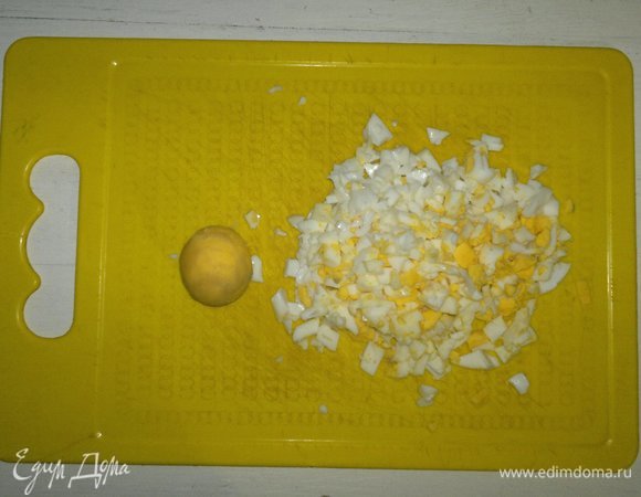 Вареные яйца почистить. Один желток отложить для украшения, остальные яйца мелко нарезать.