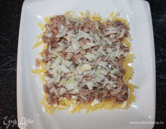 Лук репчатый мелко нарезать и выложить следующим слоем (сбрызнув лимонным соком).