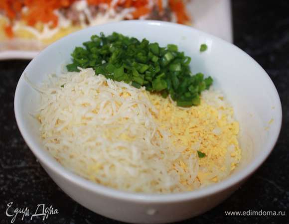 Желтки и сыр натираем на мелкой терке, мелко нарезаем зеленый лук. Нужно немного отложить тертых желтков для украшения.