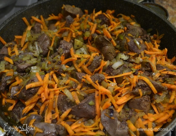 Как только печень приобрела светлый цвет (около 5минут), отправляем нарезанный лук, перемешиваем. Следом кладем натертую морковь, перемешиваем, накрываем крышкой и тушим 10 минут.