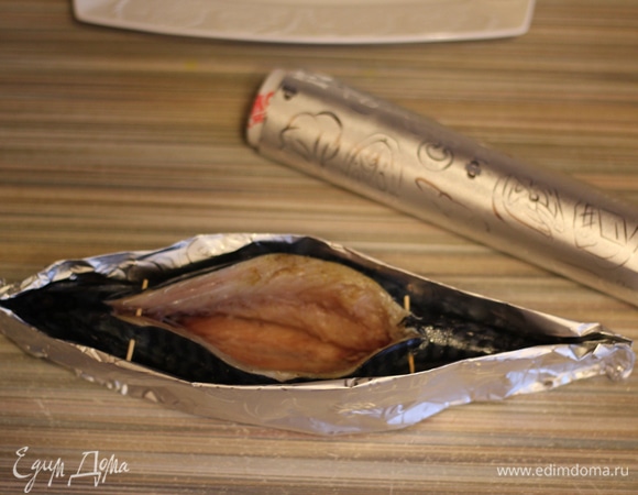 Из фольги делаем лодочку по форме тушки, зубочистками фиксируем начало и конец разреза, чтобы рыбка оставалась целой и разрез не разошелся дальше.