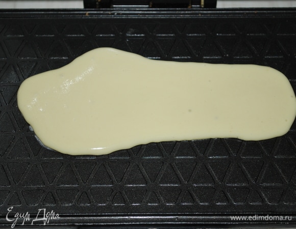 Выпекайте вафли в разогретой вафельнице до золотистого цвета. Горячие вафли заверните в трубочки, дайте им остыть.