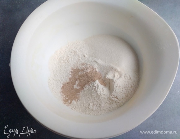 В большую миску просеять муку. Добавить дрожжи, сахар, соль. Перемешать.
