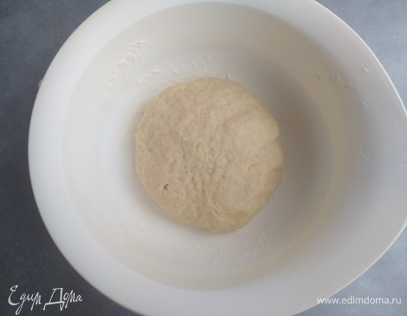 Припылить мукой (дополнительно 2 ложки) стол, замесить тесто руками, оно должно получиться эластичным. Я месила 5 минут. Можно это доверить комбайну или хлебопечке.