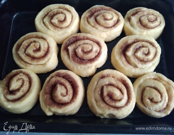 Форму смазать оставшимся маслом, разместить булочки «Синнабон» и оставить на 30 минут на расстойку. На фото уже расстоявшиеся. Выпекать 25 минут в заранее разогретой до 180°C духовке.
