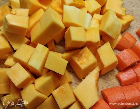 Крупным кубиком нарезать тыкву, морковь тоже нарезать толстыми полукружочками. Добавить все к мясу. Половину арахиса обжарить на сухой сковороде, порубить ножом и добавить в рагу. 