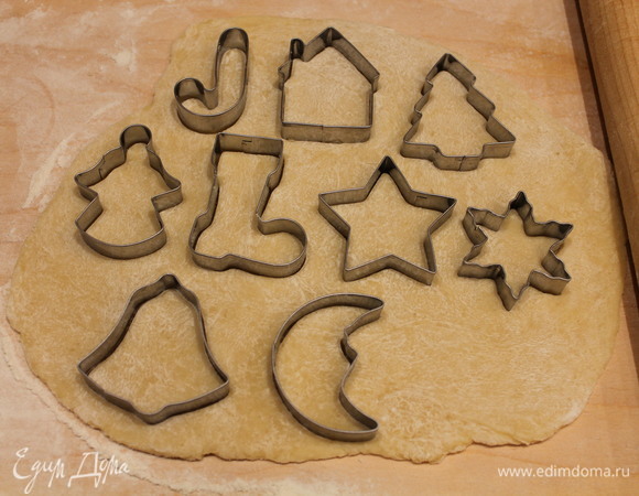 На доске раскатываем тесто толщиной примерно 5–6 мм. Вырезаем фигуры новогодними формочками.