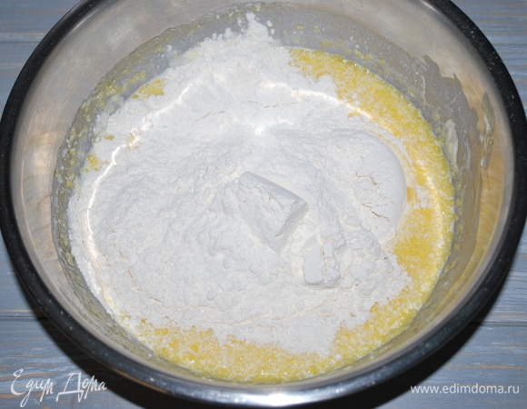 Добавьте растопленный маргарин, кефир. Всыпьте муку и замесите тесто.