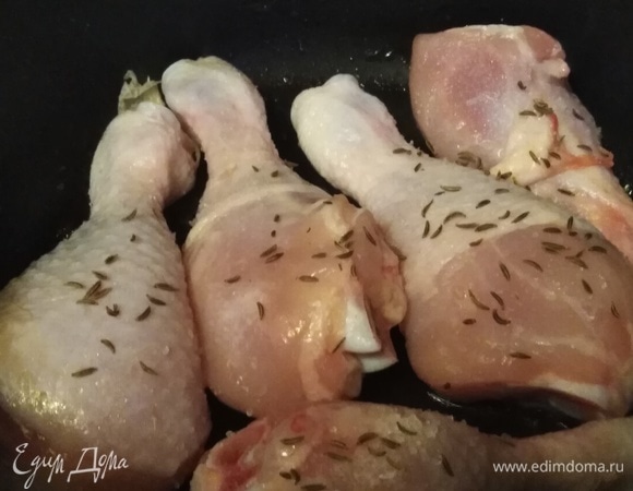 В разогретую и смазанную растительным маслом сковороду выложить подготовленные голени. Посолить. Посыпать семенами тмина. Их желательно перетереть пальцами. Поперчить. Накрыть крышкой. Жарить на среднем огне 15 минут.