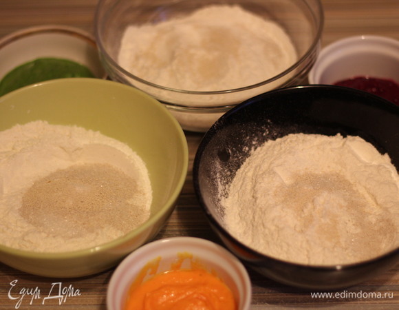 Взять три миски. В каждую высыпать по 150 г просеянной муки, по 1/2 ч. л. дрожжей, 1/2 ч. л. сахара и 1/2 ч. л. соли. Влить по 80 мл воды. В 1-ую миску добавить измельченный шпинат, во 2-ую — морковь, а 3-ью — свеклу.