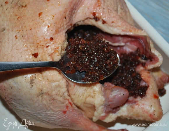 Возьмите глубокий противень. На задней части хвостика у гуся находятся сальные железы, я их срезала. Я заполнила смесью из вяленой сливы брюшко гуся, хорошо промазав все внутри.