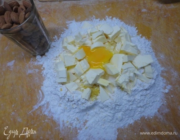 К муке добавить соль, сахар, цедру одного лимона, нарезанное кусочками холодное масло и 1 яйцо.