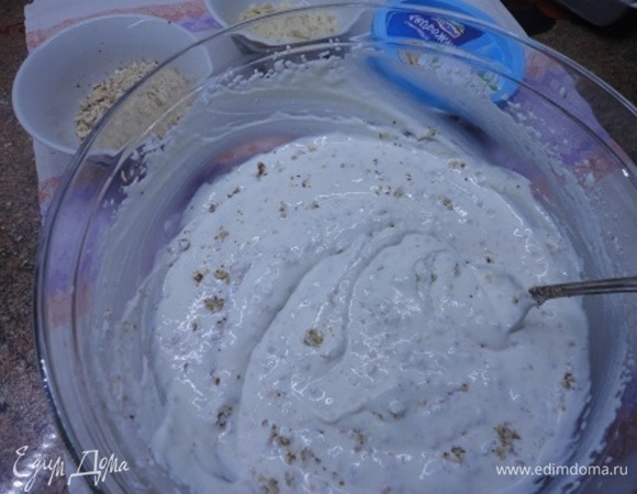 От измельченного миндаля оставляем пару ложек для посыпки сверху, а остальной миндаль и миндальную эссенцию смешиваем с кремом.