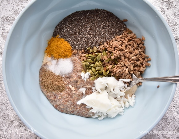 В миске смешать измельченную смесь семян гречки и пшена, замоченные в воде измельченные льняные семена, промытые семена тыквы и подсолнечника, семена чиа, гашеную соду, кокосовое масло, соль, молотый тмин и кориандр, куркуму. Немного семян подсолнечника, тыквы и льна оставить для посыпки хлеба сверху.