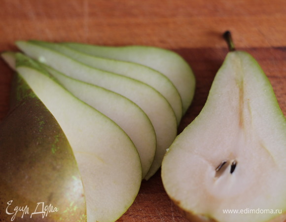 Грушу разрезать пополам, удалить семечки и нарезать тонкими ломтиками. Сбрызнуть соком лимона, чтобы груша не потемнела.