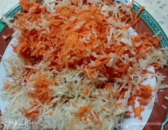 Морковь и корень сельдерея натираем на мелкой терке. К этому времени лук поменял цвет, и можно к нему добавить морковь с сельдереем и чесноком. Все это тушим на среднем огне минут 5–10.