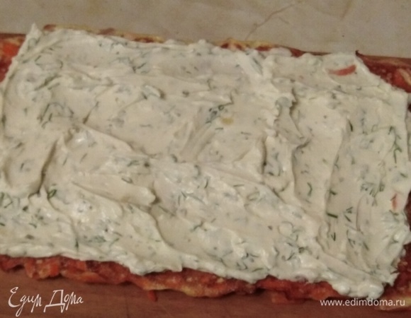 Выложить начинку на морковный пласт, оставив небольшие зазоры по бокам. Разровнять.