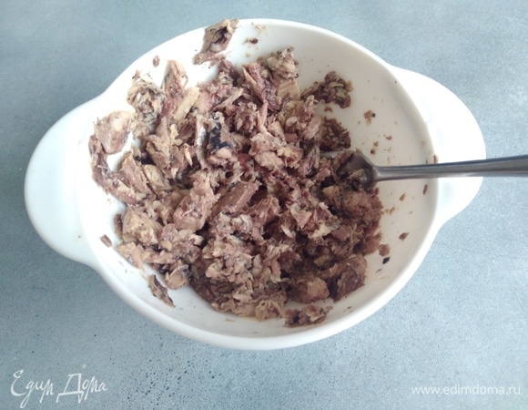 Консерву размять вилкой вместе с половиной сока из рыбы. Добавить к сыру.