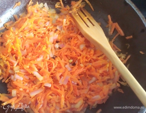Влить на сковородку масло. Добавить тертую морковь, лук и обжарить в течение 5–7 минут, постоянно помешивая.