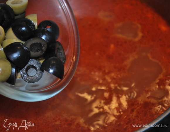 К бульону добавьте обжаренные морковь с луком, оливки, проварите 1–2 минуты. Отрегулируйте соль и перец по вкусу.