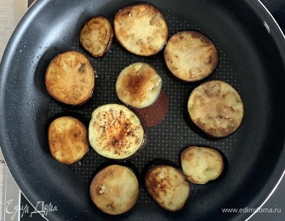 Обжариваем баклажаны с двух сторон на подсолнечном масле, а затем лишнее масло удаляем бумажными полотенцами.<br />
Баклажаны заранее вымачиваем в холодной подсоленной воде и высушиваем.