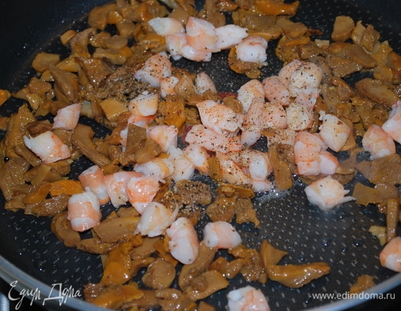 Грибы обжарьте на масле в течение 6–7 минут. Добавьте нарезанные креветки и обжарьте все вместе еще пару минут. Добавьте черный молотый перец по вкусу.