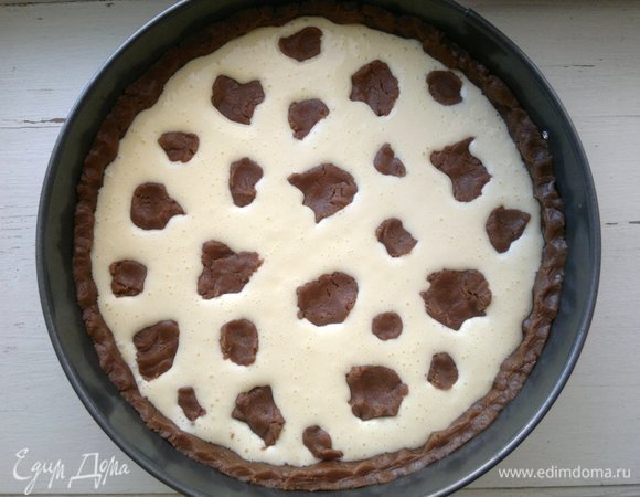 Оставшуюся часть теста разделить на кусочки разной величины и формы и выложить на начинку. Поставить пирог в духовку, разогретую до 180°C, на 50–60 минут. Во время выпечки начинка будет слегка подниматься. По окончании выпечки пирог сразу не вынимать из духовки. Дать ему постоять в выключенной духовке при открытой дверце 15–20 минут. За это время начинка вернется на место.