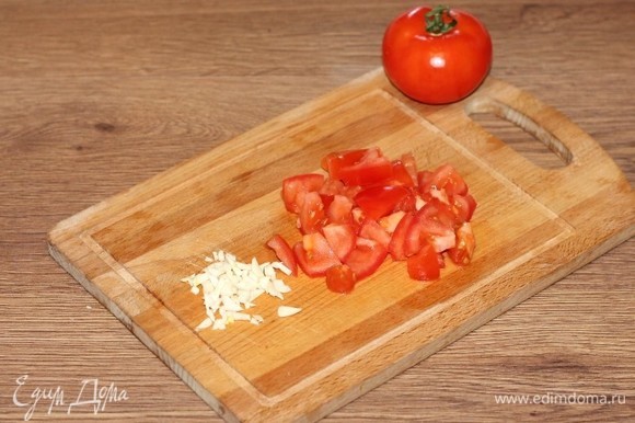 Затем добавляем нарезанный дольками помидор (небольшой) и очищенный и нарезанный чеснок.