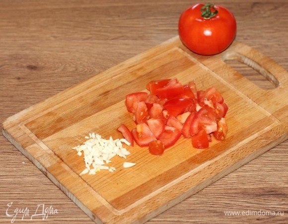 Затем добавляем нарезанный дольками помидор (небольшой) и очищенный и нарезанный чеснок.