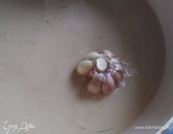 В сковороде разогреть масло. Выложить вторую половину головки чеснока.