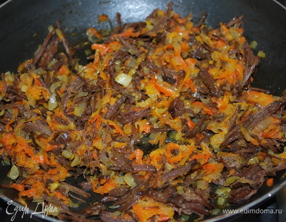 К обжаренному луку добавьте отварное мясо (у меня мясо говядины), разобранное на волокна.