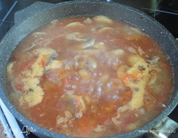Добавить рубленый чеснок, протертые помидоры, влить бульон. Довести до кипения.
