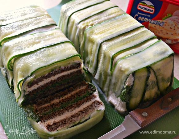 После охлаждения выложите закусочный торт на разделочную доску и с помощью острого ножа нарежьте на порционные куски.