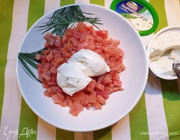 Добавим к рыбе половину баночки творожного сыра, посолим и хорошо перемешаем.