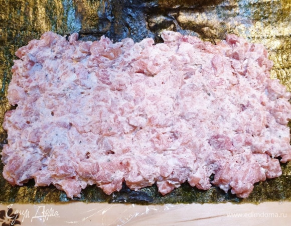 Выложим 2 листа нори на пищевую пленку. Распределим рыбно-творожную смесь на нори.