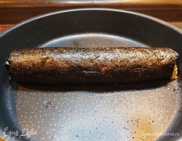 Выкладываем рулет на сухой противень, освобождаем от пленки и запекаем в духовке, разогретой до 180⁰С, в течение 15–17 минут.