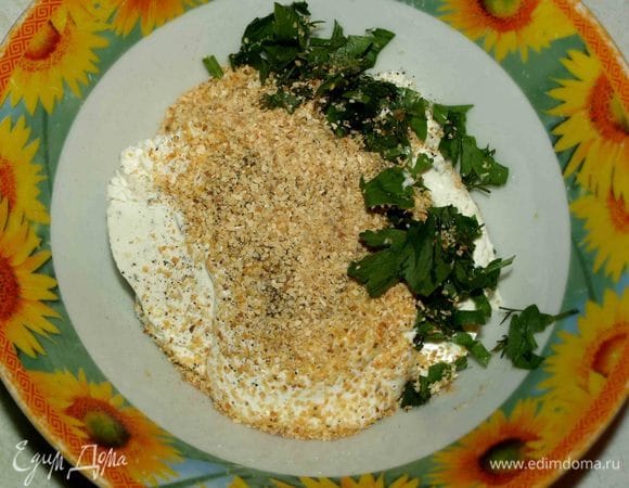 В миску выкладываем творожный сыр с зеленью Hochland и сметану. Добавляем рубленую зелень, соль, перец, чеснок. Все хорошо перемешиваем.