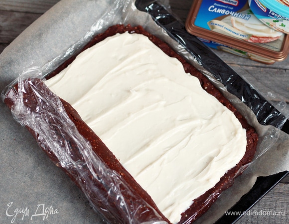 Сверху равномерно распределить крем, отложив 1/4 часть для покрытия торта (хранить в закрытой емкости). С узкой стороны аккуратно свернуть в плотный рулон, но при этом сильно не придавливать, чтобы крем не вышел за пределы.