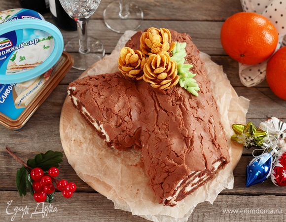 Раскатать пласт отделочного материала на пищевой пленке и аккуратно перенести на поверхность торта. Сделать некую небрежность, придав вид древесной коры. Основа для шишек была сделана из смеси остатков от выравнивания торца «Полена» и «мастики».