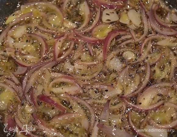 Когда специи начнут благоухать, добавить оливковое и сливочное масло, выложить лук с чесноком и обжарить.