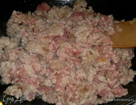 Добавить в сковороду фарш. Продолжать обжаривать до изменения цвета, все время помешивая и разбивая лопаткой комочки.