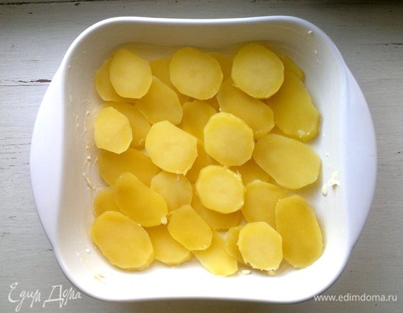 Форму смазать кусочком сливочного масла. Картофель нарезать кружками и выложить в форму.