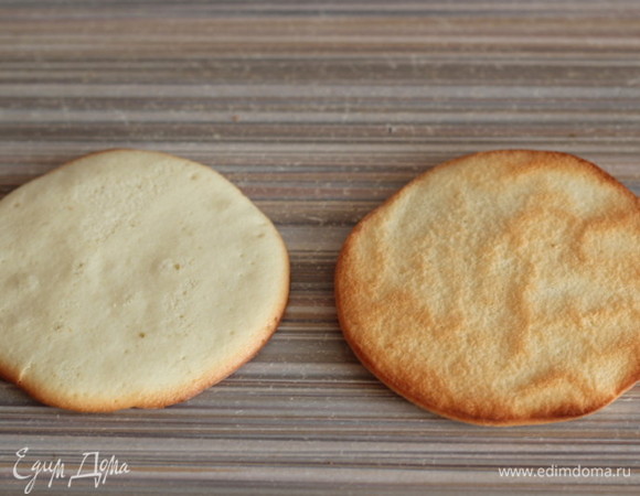 Готовые бисквитные лепешки переворачиваем и сразу снимаем пергамент.